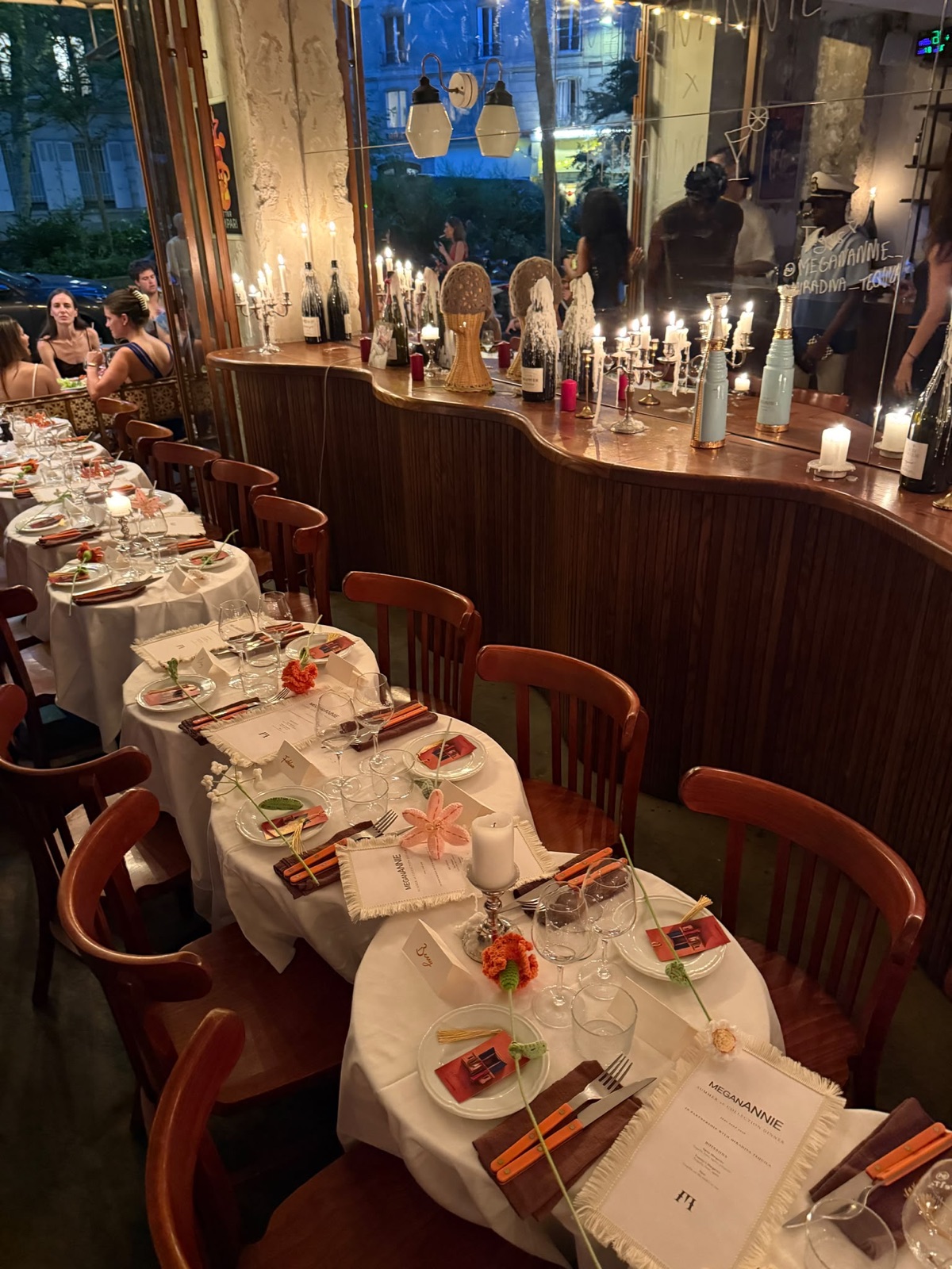 La salle de Chez Yvette dressée le soir pour un dîner événement, bougies, couverts orange et menus, avenue Trudaine, Paris 9e